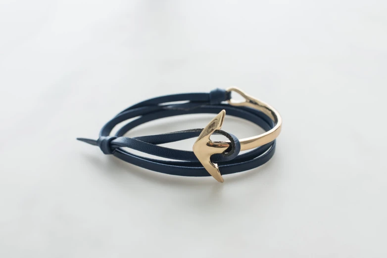 the gold anchor on this navy leather celet is handmade and is ready to be worn