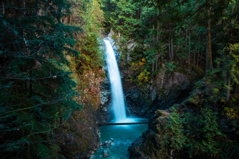 the beautiful waterfall has a blue pool near it