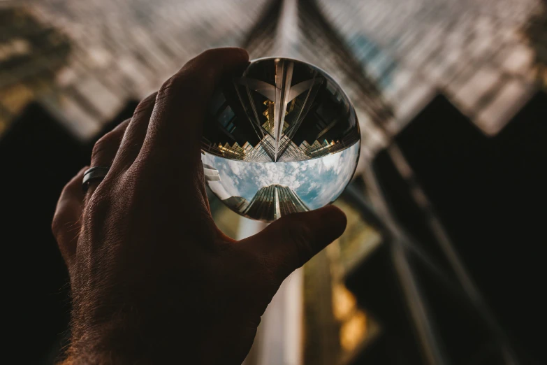 someone is holding up a small glass ball