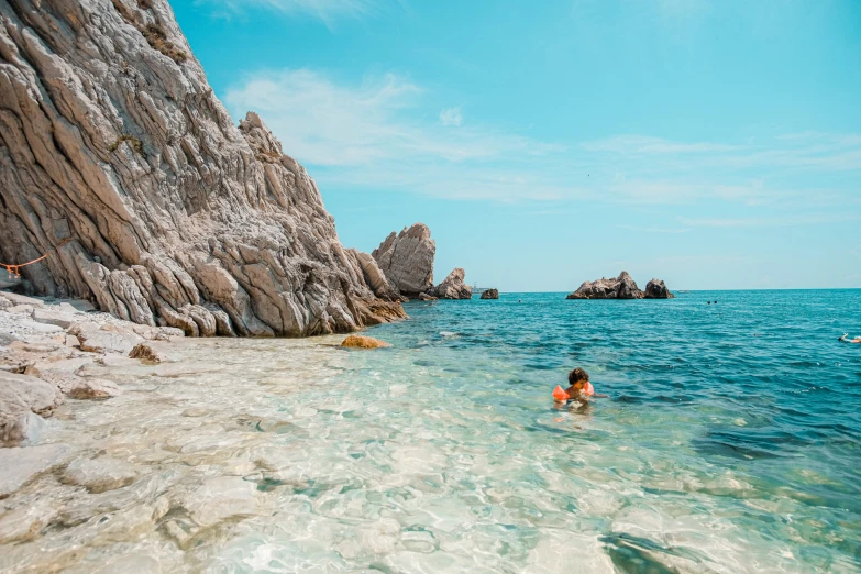 an ocean with people in it on top of rock formations