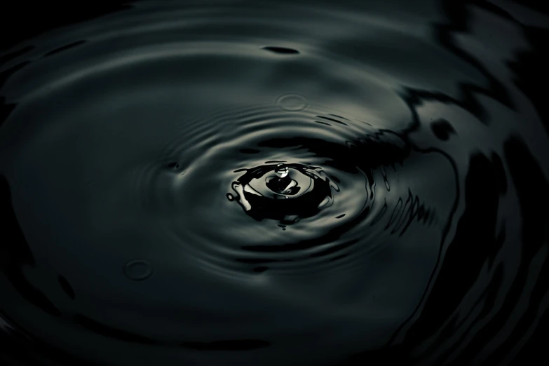 a water drop with a black background is the only thing that can be seen here