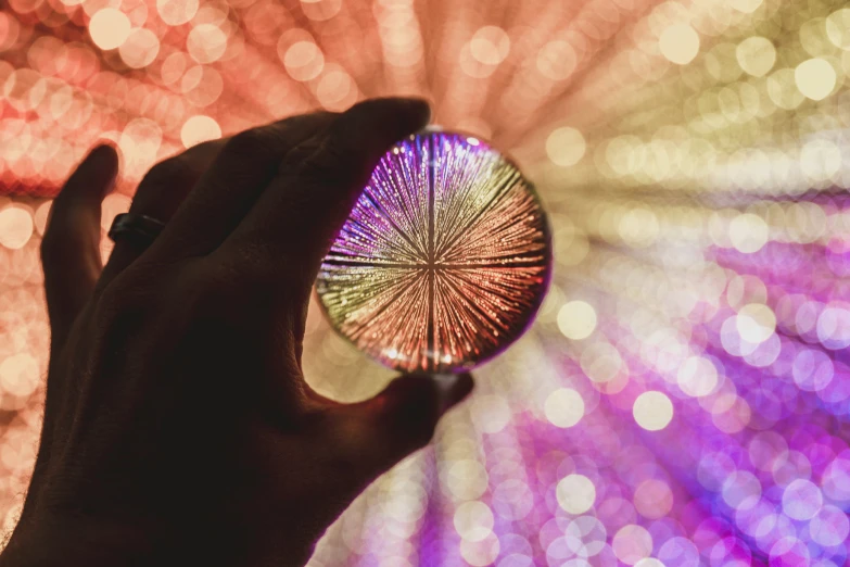 a person is holding up a glass ball