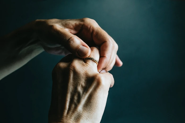 someone holding hands together and touching their ring