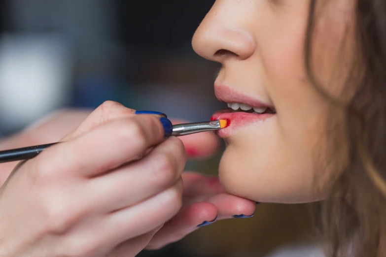 a woman is doing makeup with a small brush