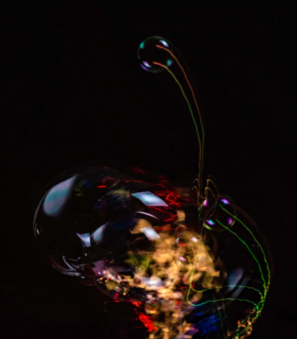 an apple shaped balloon filled with a colorful liquid