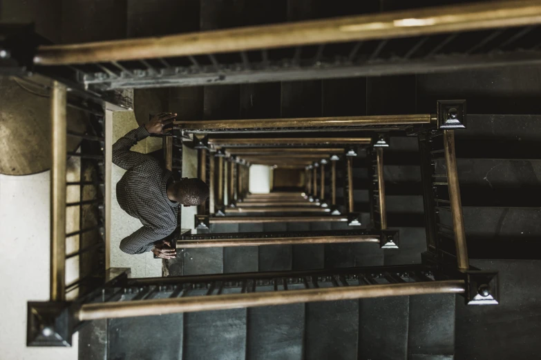 a man climbing up the side of a metal stair case