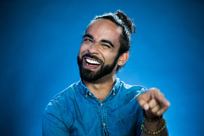 a young man with a beard holding his hands together