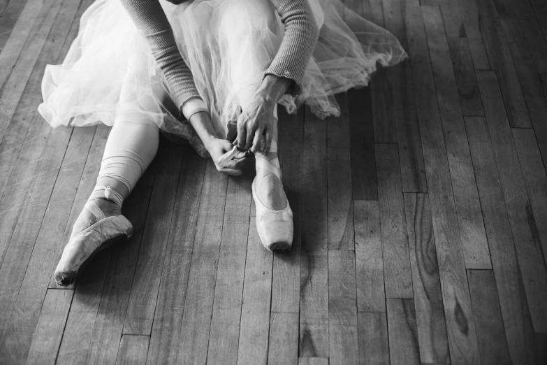 a woman in a ballerina outfit sitting on the floor