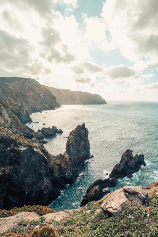 ocean cliffs at sunset with clouds above them