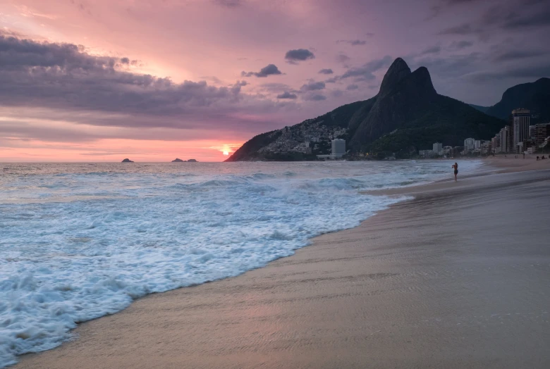 waves crashing onto the beach as the sun sets