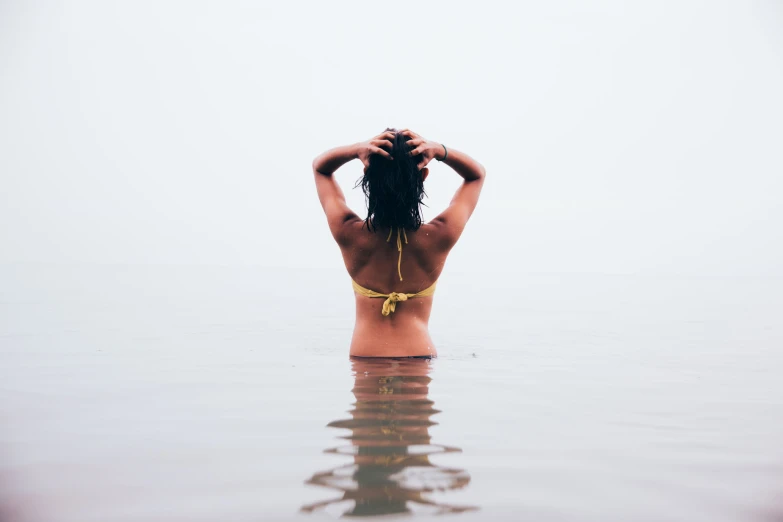 a girl in a bikini paddling in the water