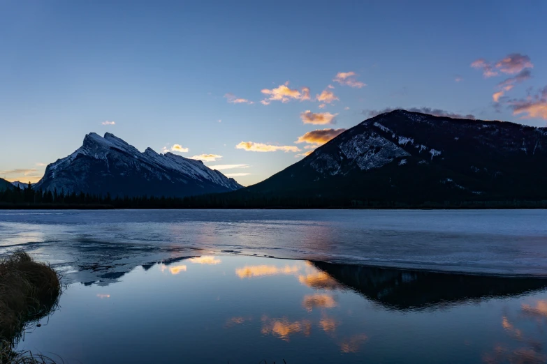 a very beautiful looking body of water with mountains in the background