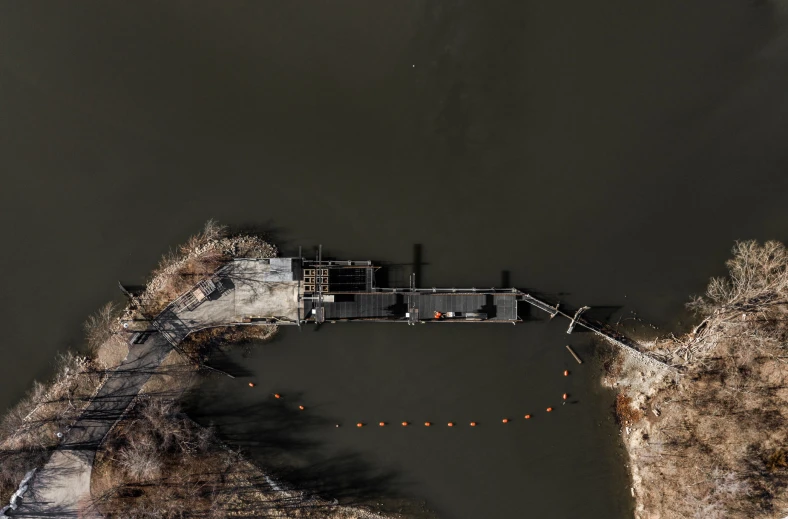 a body of water next to a dock and tree lined shore