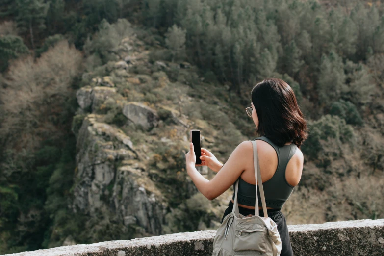 a woman is using a cell phone with her back to the camera