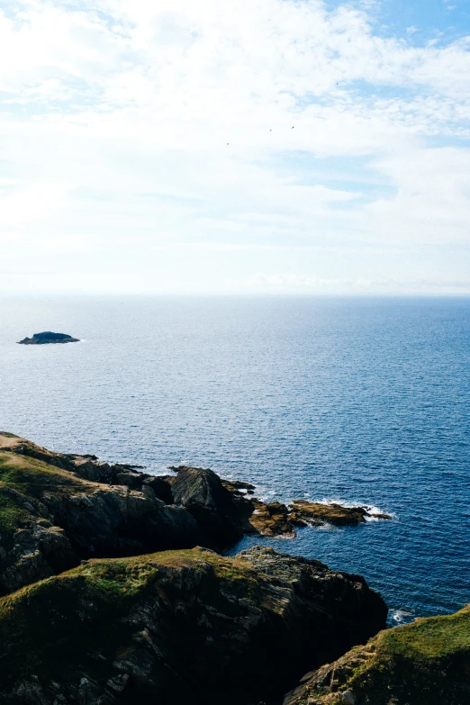 the sky above a body of water near a rocky cliff