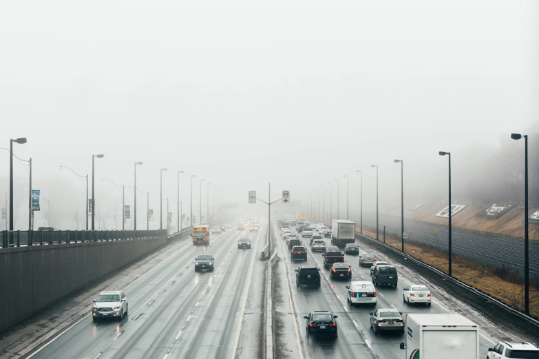 cars traveling down a highway in a foggy day