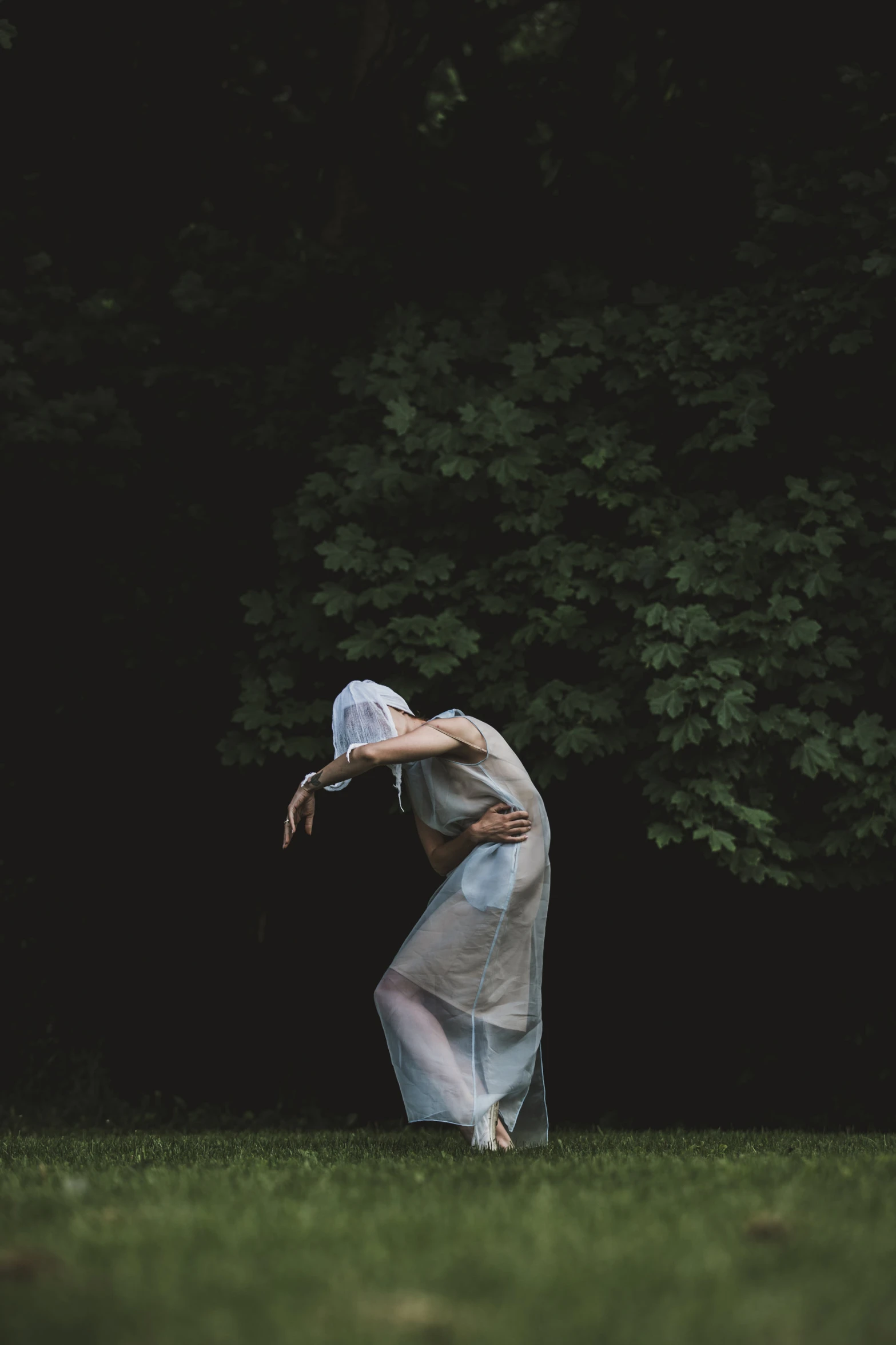 a woman reaching for a frisbee in the dark