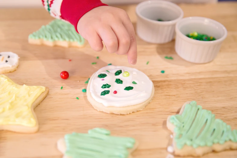 there is a child making some christmas cookies on the table