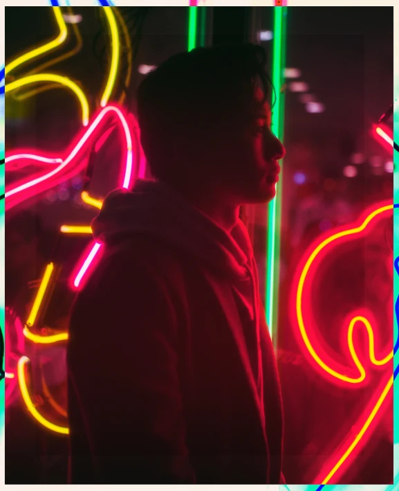 a man looks up at the neon lights