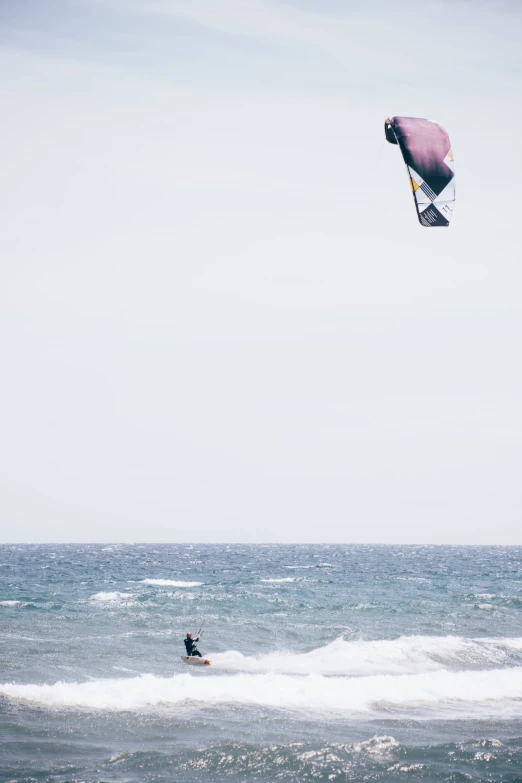 a surfer rides a wave while wind surfing