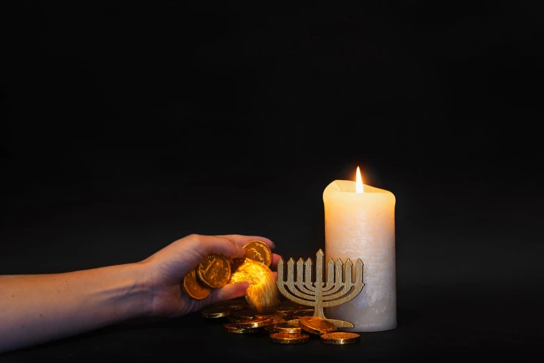 a person holds a gold hanukkah in front of them