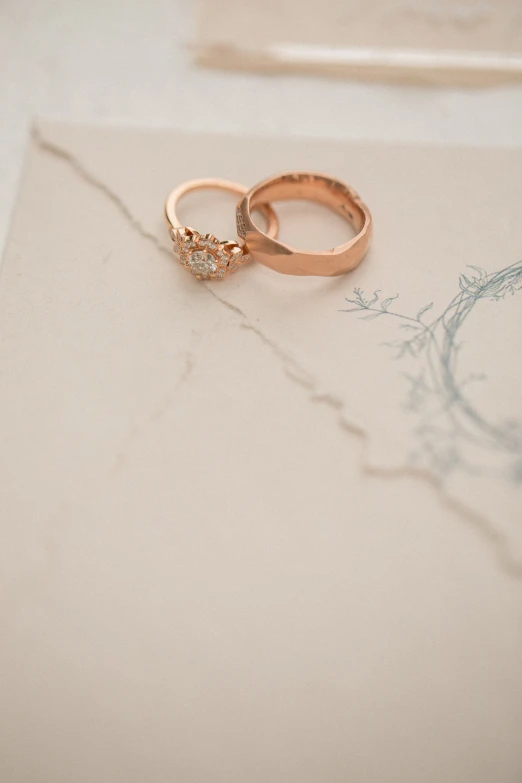 two wedding rings with diamonds on a sheet