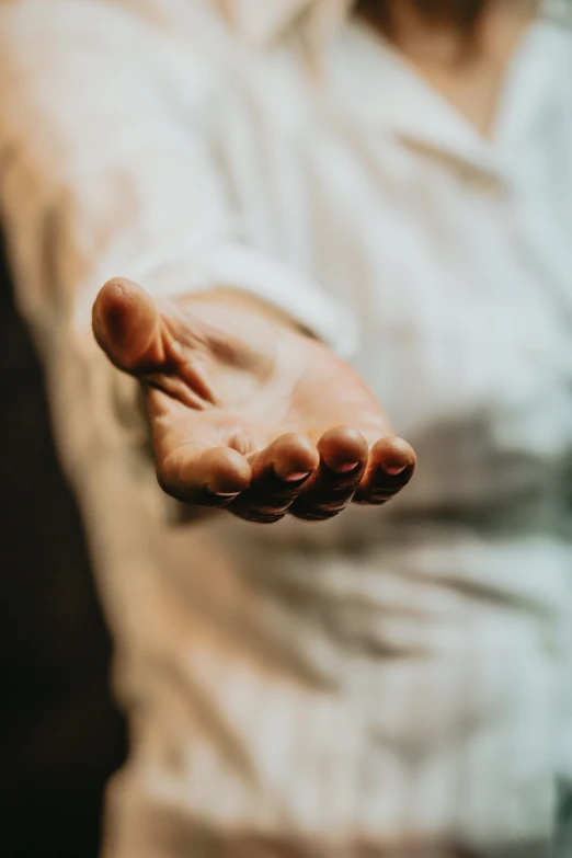 a person with their hand stretched out to hold soing in the air