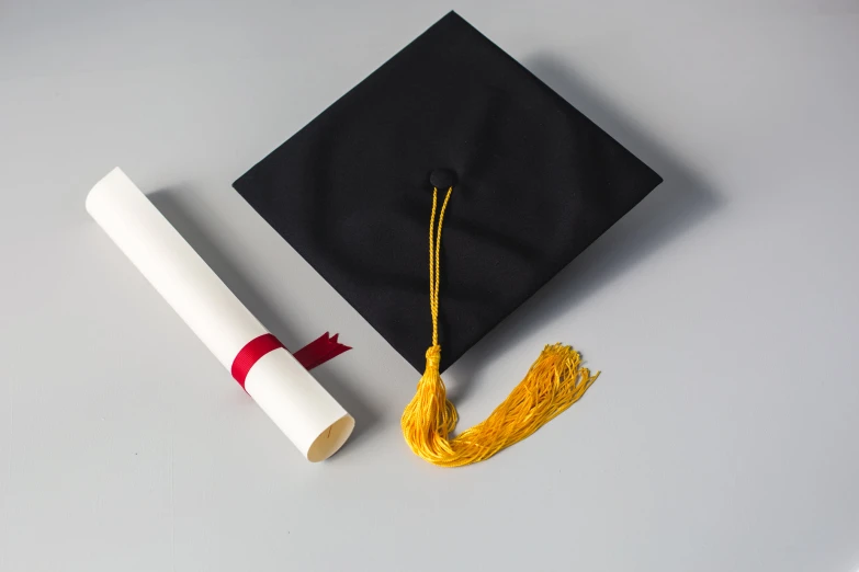 a black graduation cap, white tassel and yellow tassel