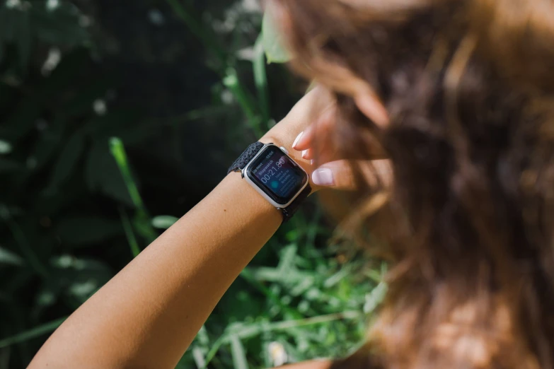 a woman holding her arm as she uses her cell phone