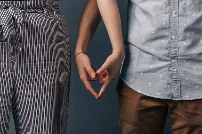 an image of two people making heart signs