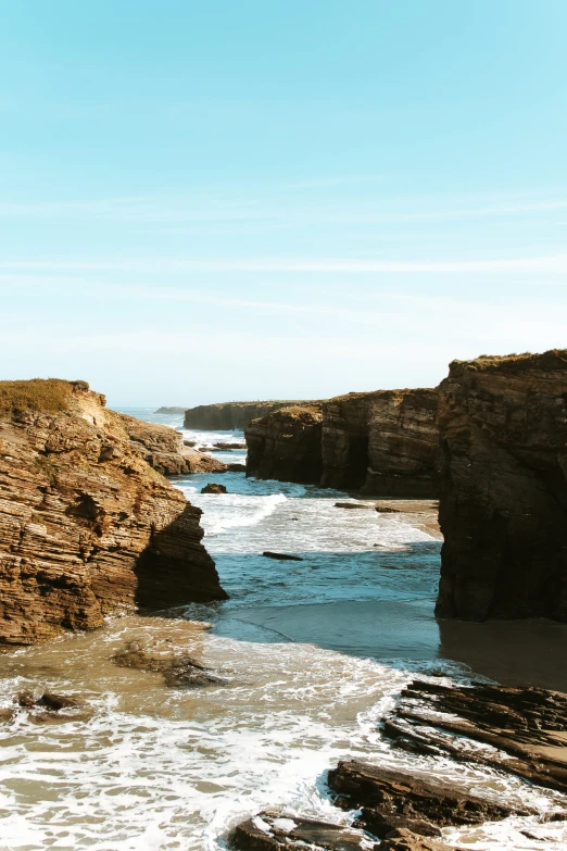 water flowing through to the beach by some cliffs