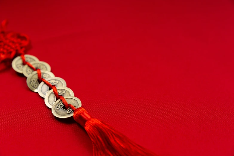 a red table cloth with silver coins with a red tassel