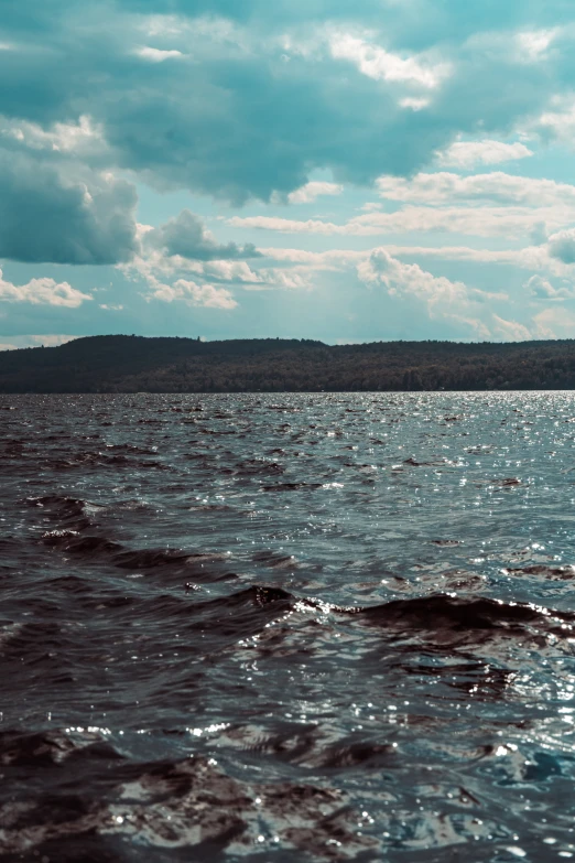 a large body of water sitting below a cloudy sky