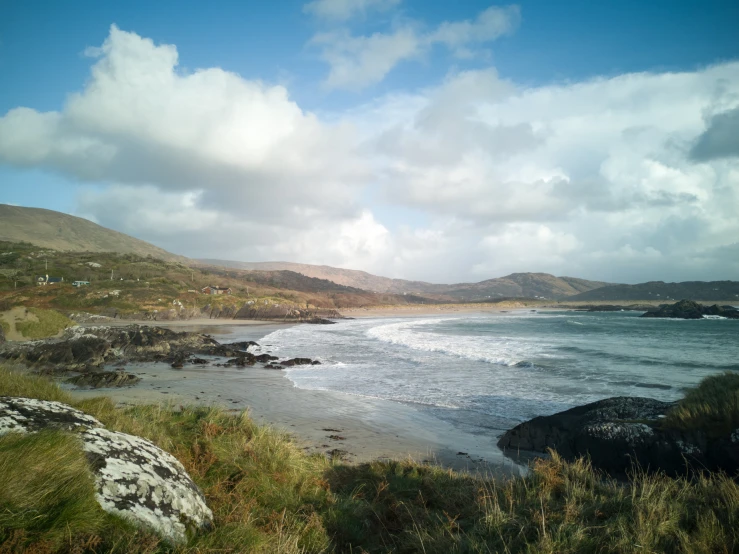 a small beach and some large mountains on the other side