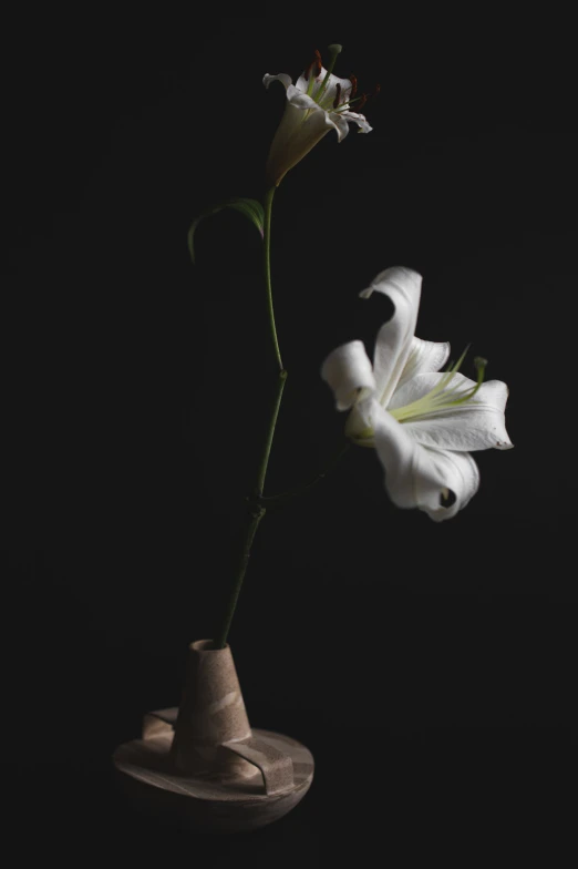 a white flower in a small ceramic vase