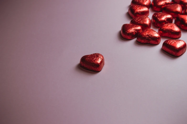 a red heart shaped candy on top of a table