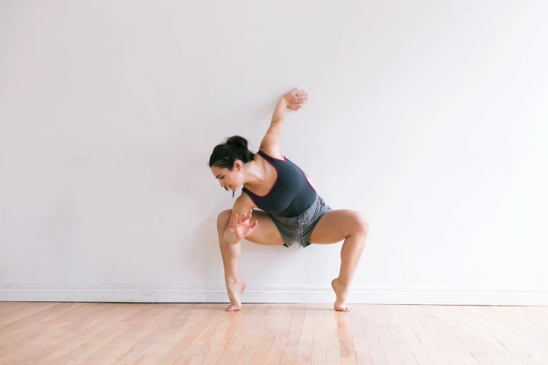 a woman in a yoga position with her hands raised