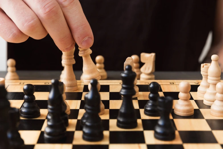 someone is playing a chess board game with pieces arranged in squares