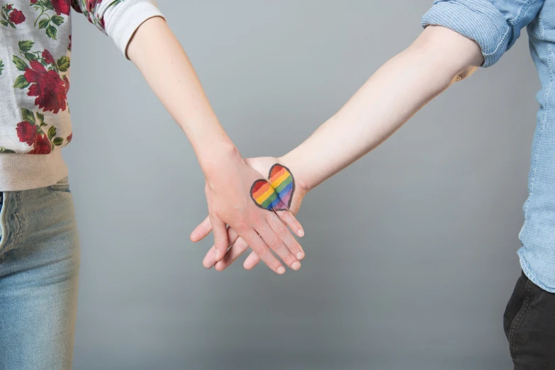 a couple is holding hands that are heart shaped