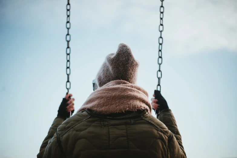 a woman swinging on the chains of a swing