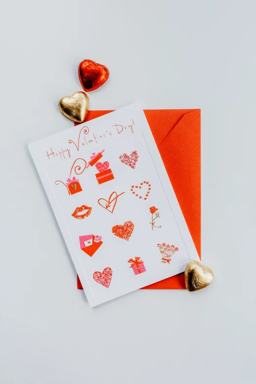 two heart shaped chocolate candies on an orange envelope