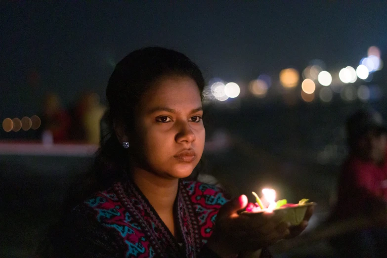 a woman holding an oil lamp in her hand