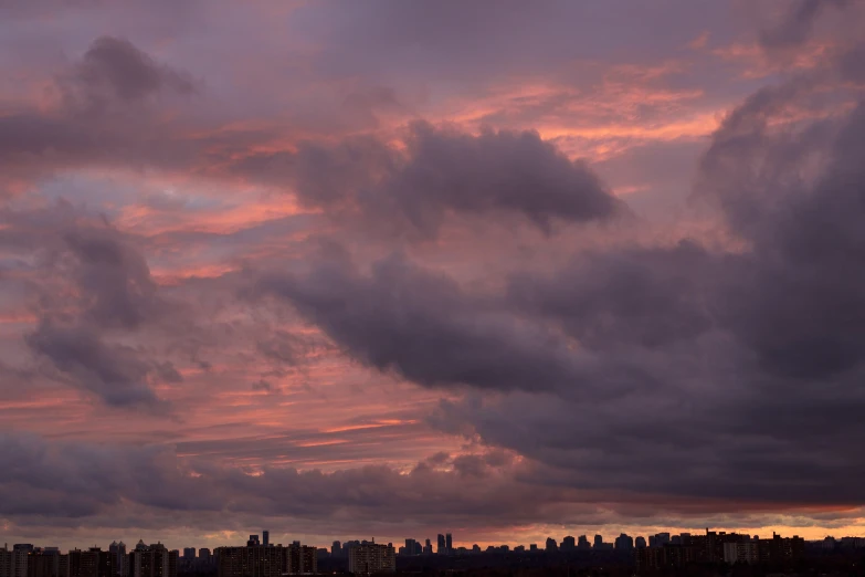 sunset sky clouds over the city with airplane coming in