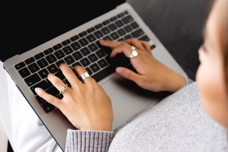 a woman working on her laptop computer and typing on her finger