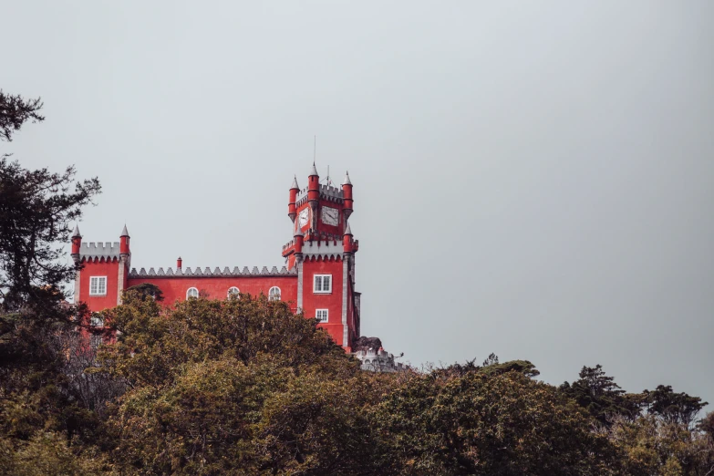 an orange building stands among trees against a light gray sky