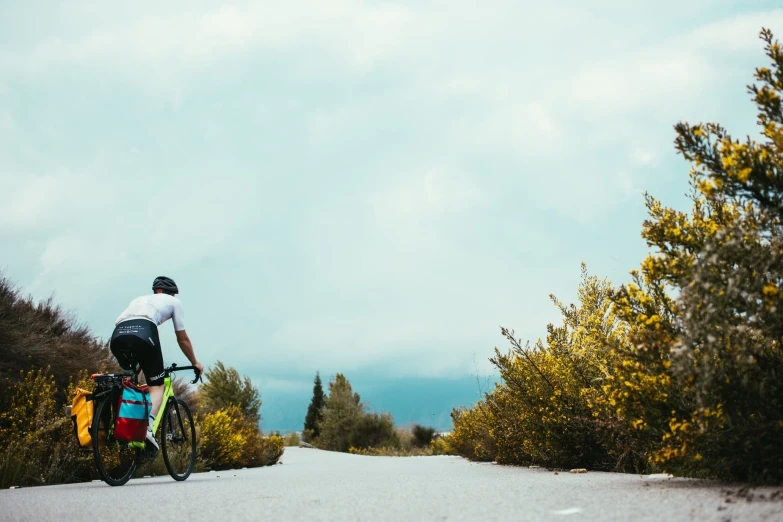 a man riding his bike down a rural country road