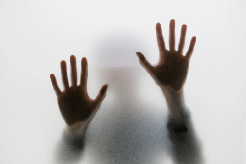 a shadow of a hand reaching towards a white background