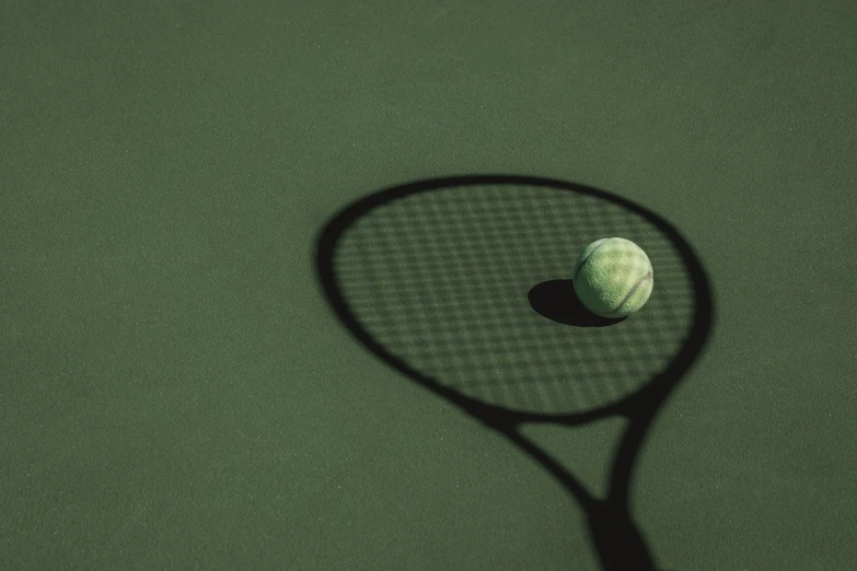 a tennis racket with a ball sitting on the side