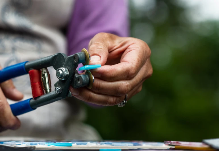 a person using a pair of pliers to cut paper