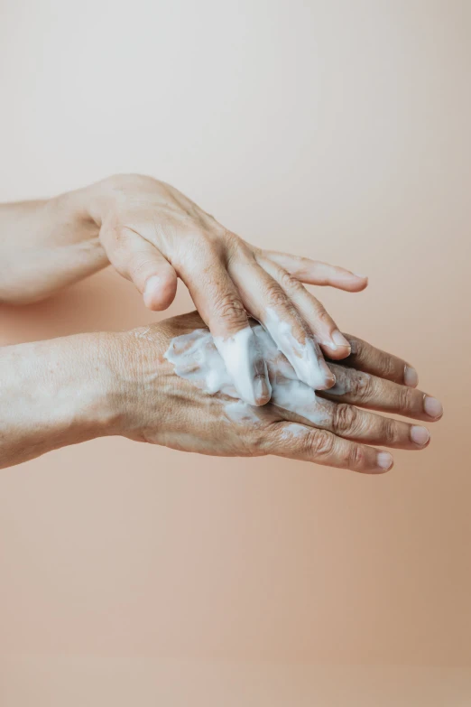 two hands reaching out toward each other with white powder on them